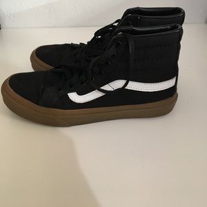 A pair of black and brown high top vans.