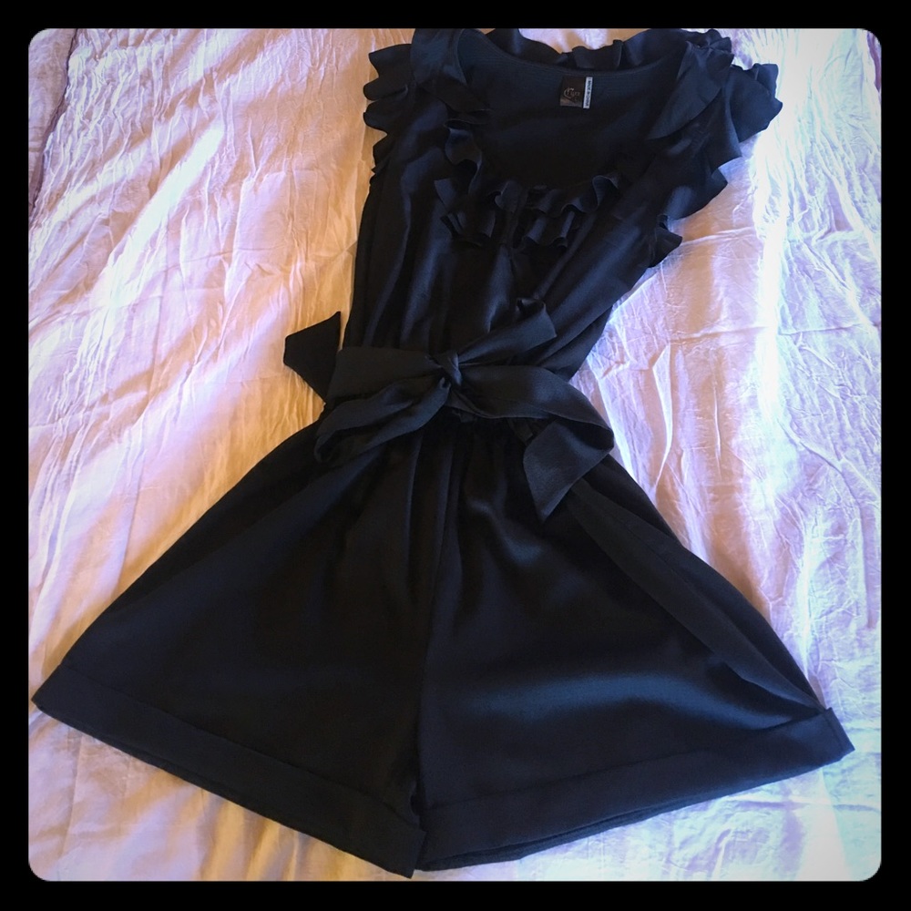 Black silk like Romper. Ruffled collar and sleeves