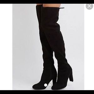 Black thigh high boots .