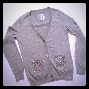 Grey Justice sweater with sequin pockets.