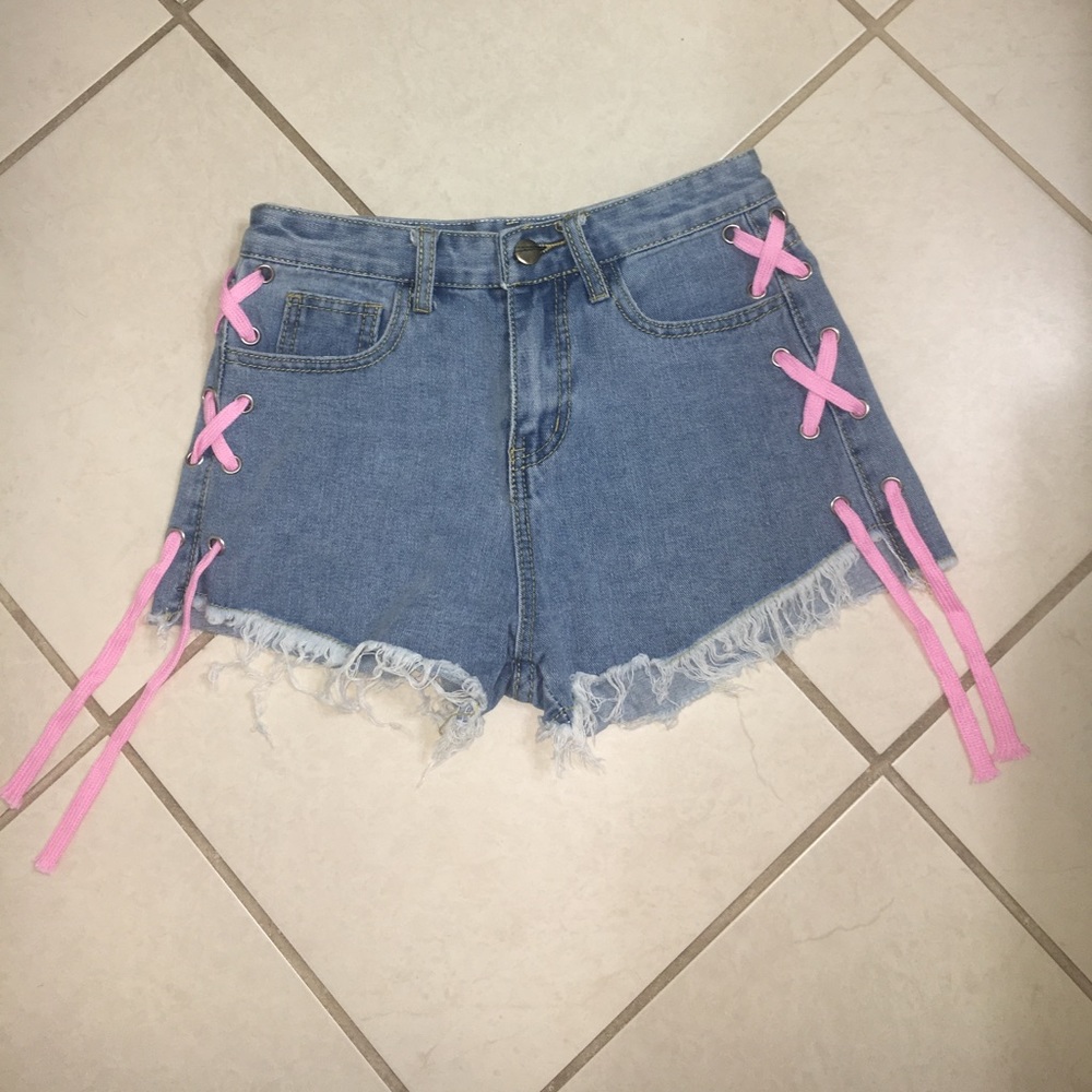 Light wash jean shorts with a pink  laced side