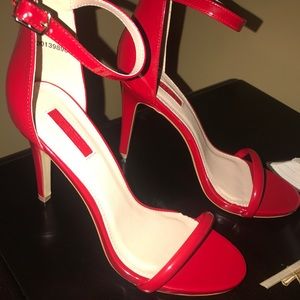 Red faux leather pumps