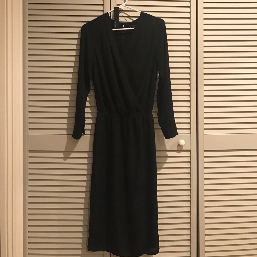 Mid-length black dress with slit.