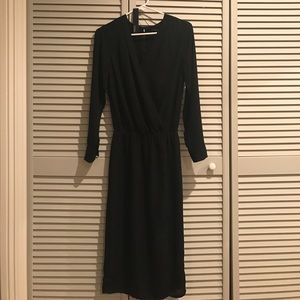 Mid-length black dress with slit.