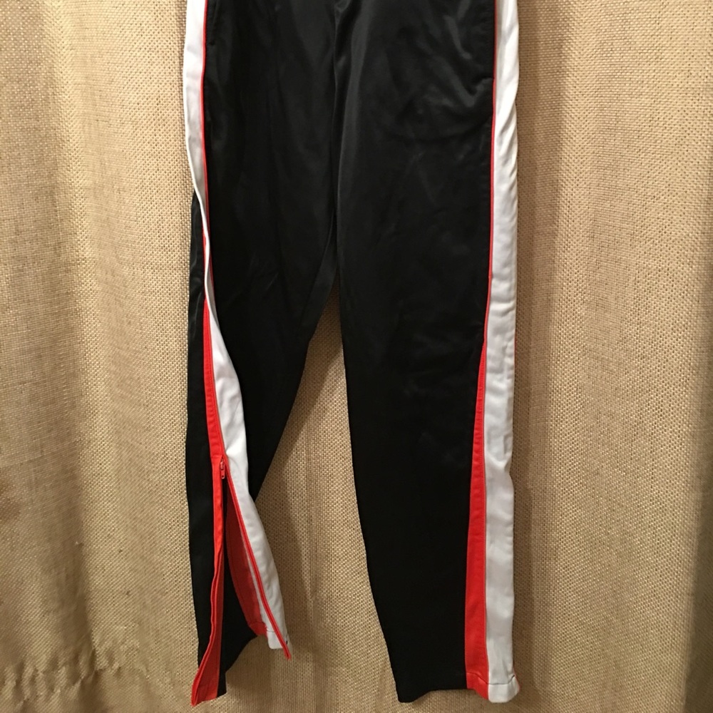GTM Sportswear. Black/orange/white pants.