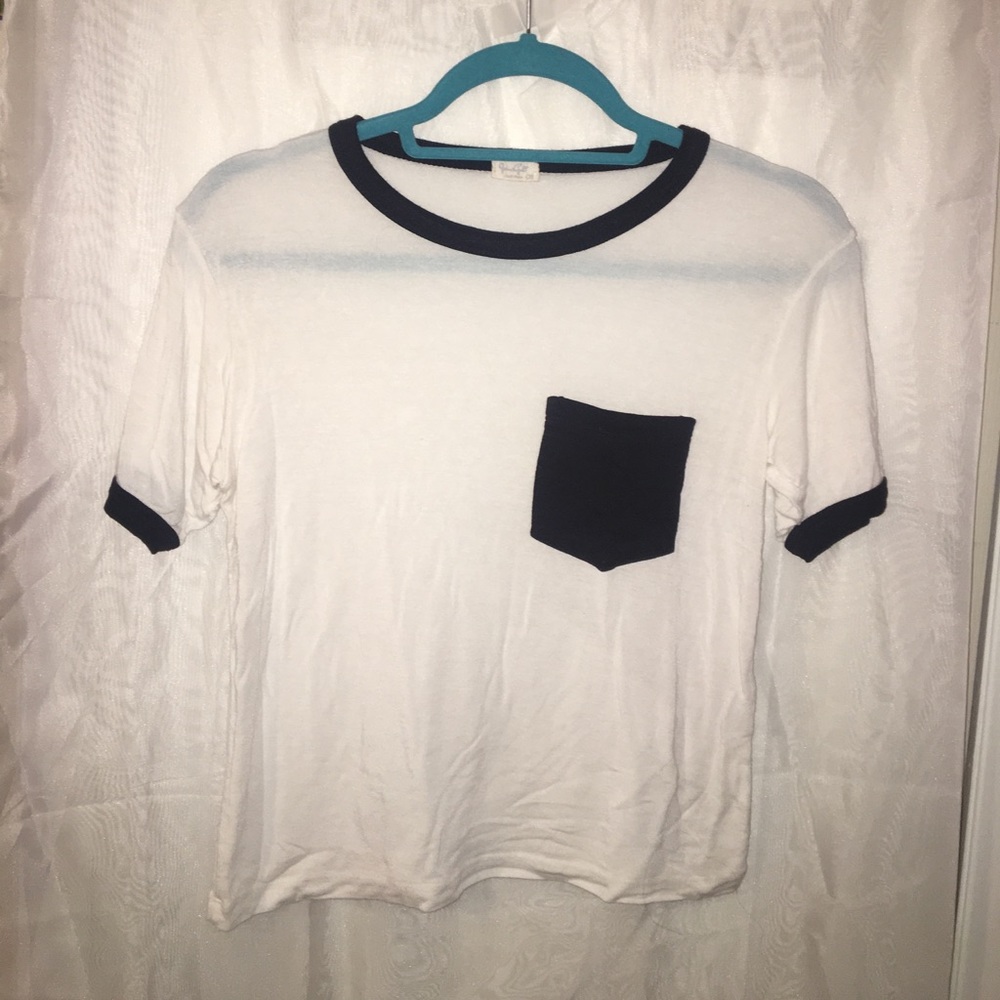 Light cream t-shirt with black front pocket.