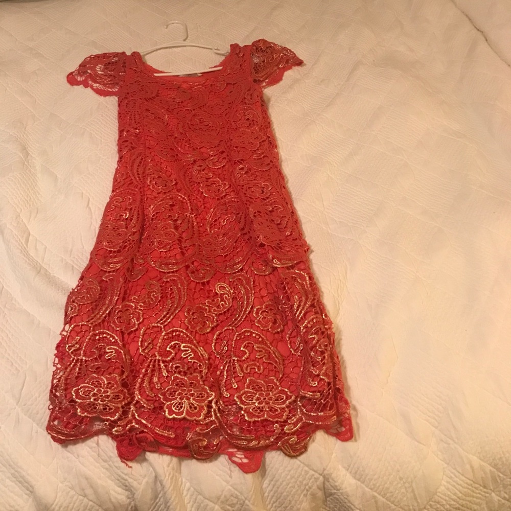 A pink laced dress with golden accents