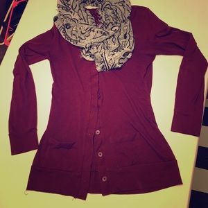 Maroon sweater with black and white scarf.