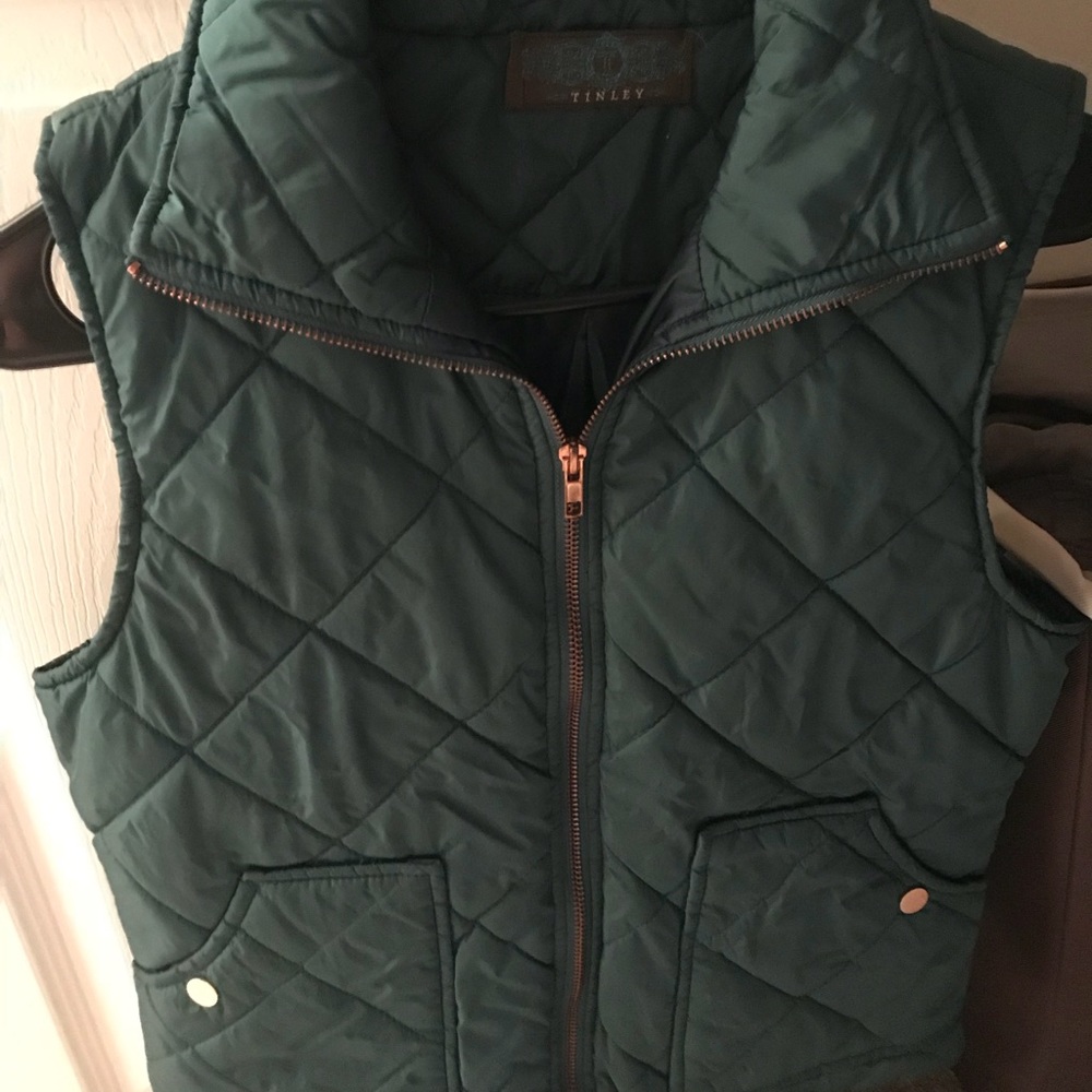 Dark green puffer vest with gold accents