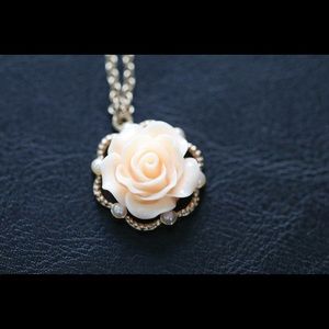 Gold necklace with pastel pink flower