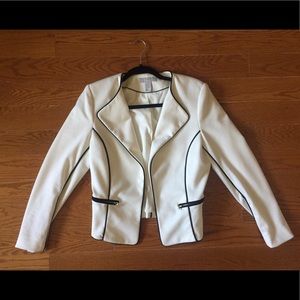 White blazer with black trim and gold detailing