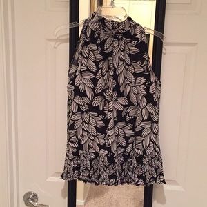 High-collar sleeveless blouse with keyhole details.