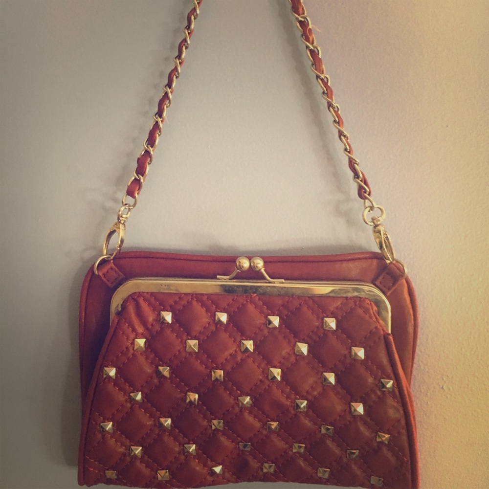 Red clutch style purse with studs and chain strap