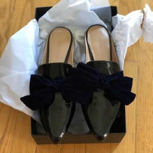 Black patent leather mules with blue velvet bow.