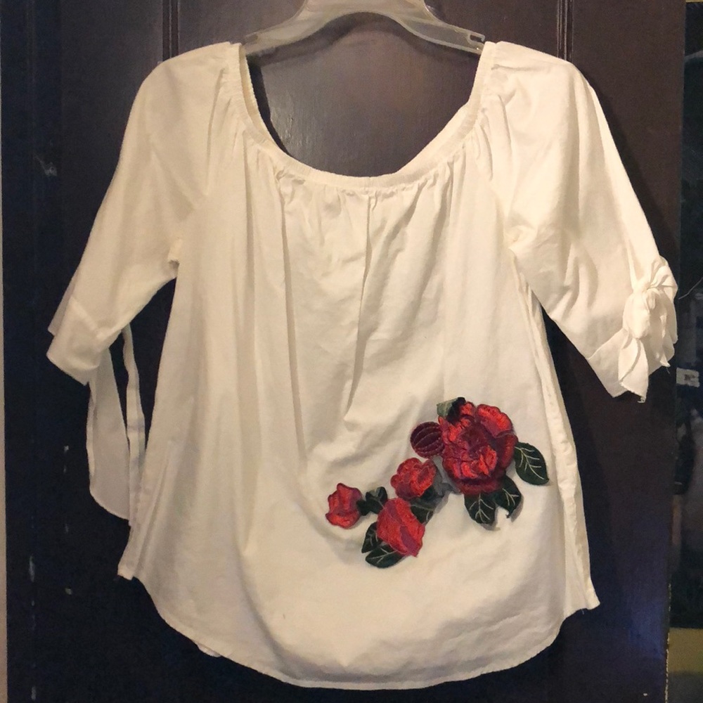 Off the shoulder white shirt with a 3D rose.
