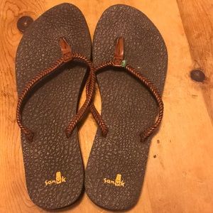 yoga mat sole with tan braided leather strap.