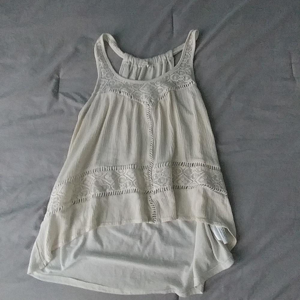 A cream tank top with lace detailing.