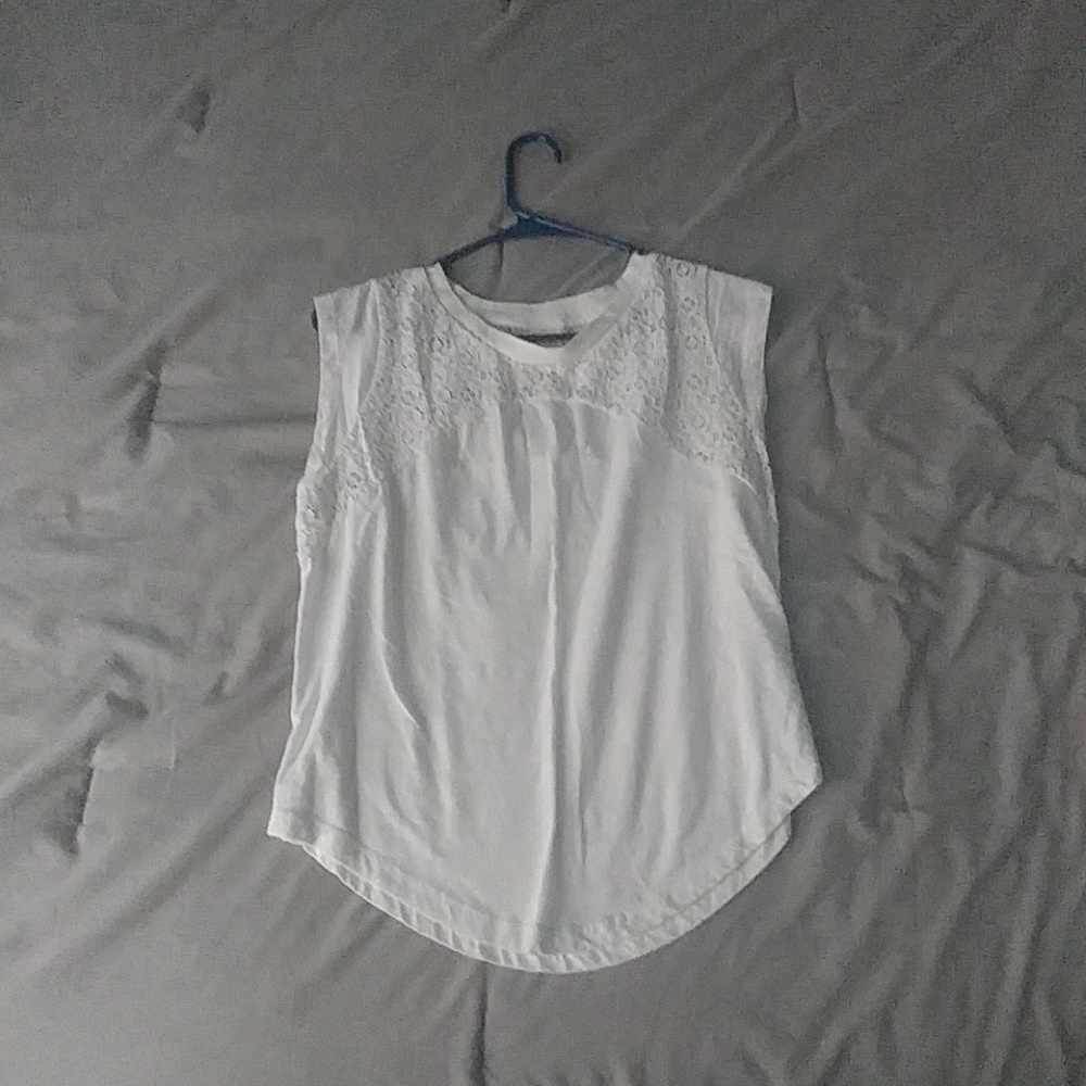 A white blouse with a lace detailing at the top.
