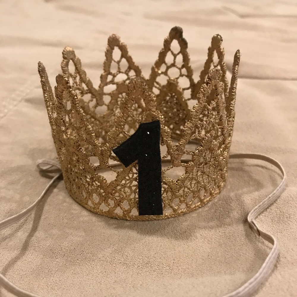 Gold and black number “1” crown with elastic strap