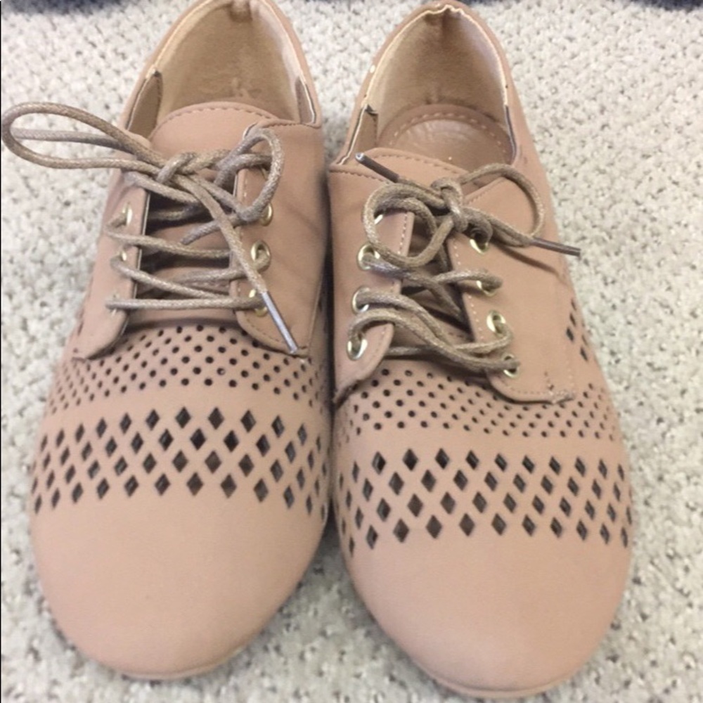 Tan flat shoes lace up w designs on them