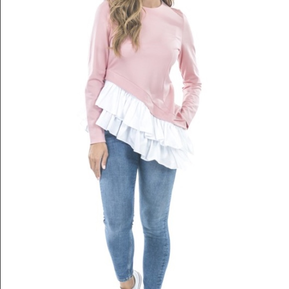 Pink blouse with white accent ruffles.