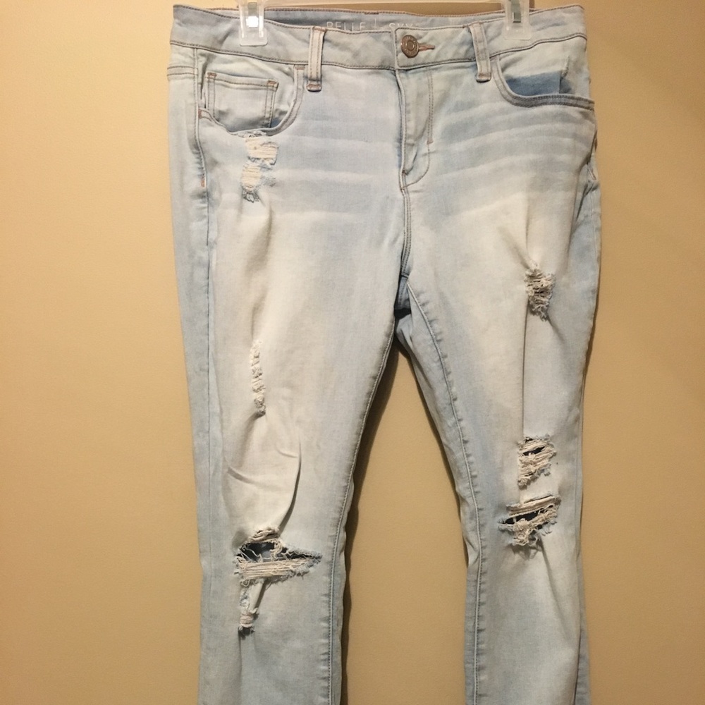 Pale jeans with ruffed ends and holes in the knees