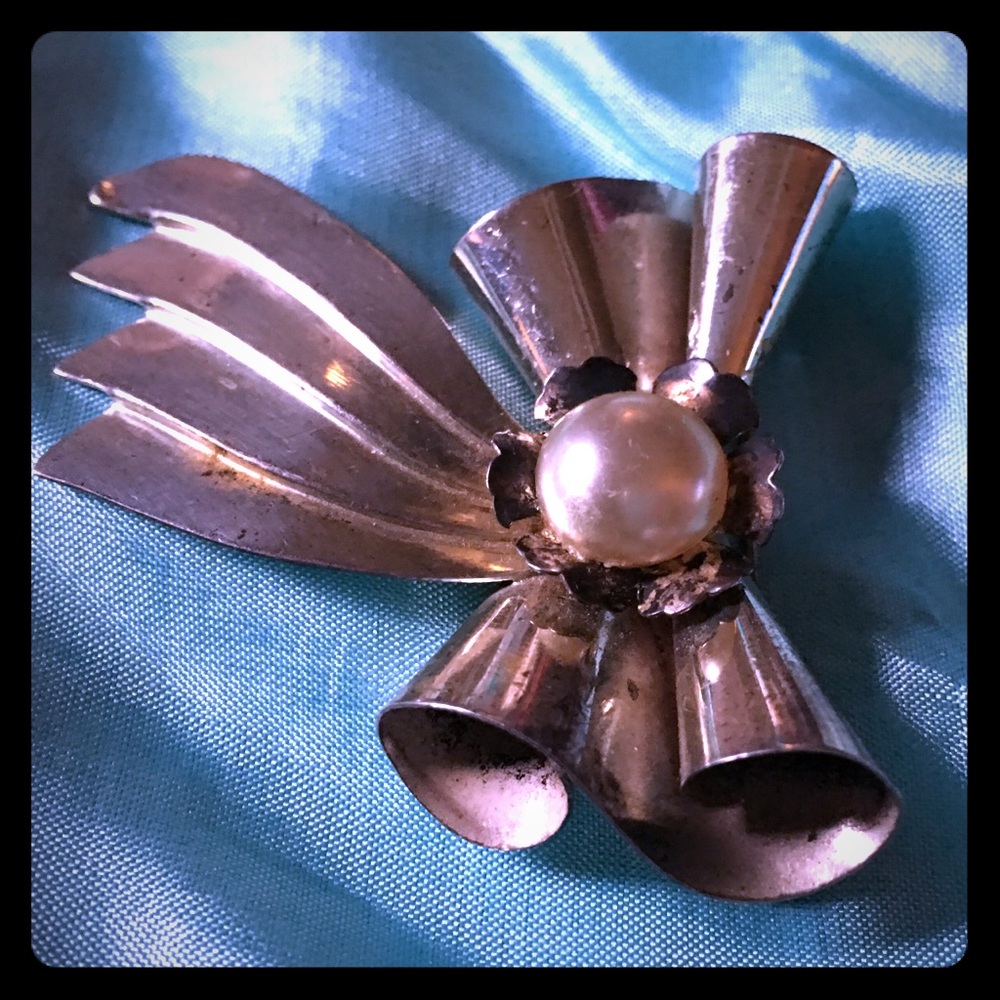 Silver metal bow-pin with pearly center. Sterling?