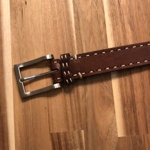Brown leather belt with cream stitching.