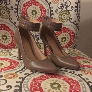 Dark beige pumps with ankle strap.