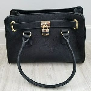 Black satchel with gold lock detail and hardware