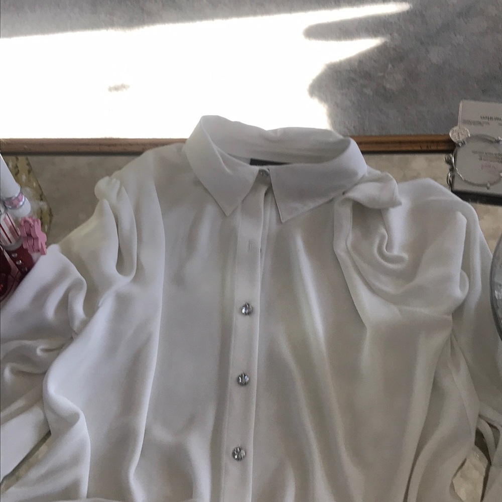 A white blouse with rhinestone buttons