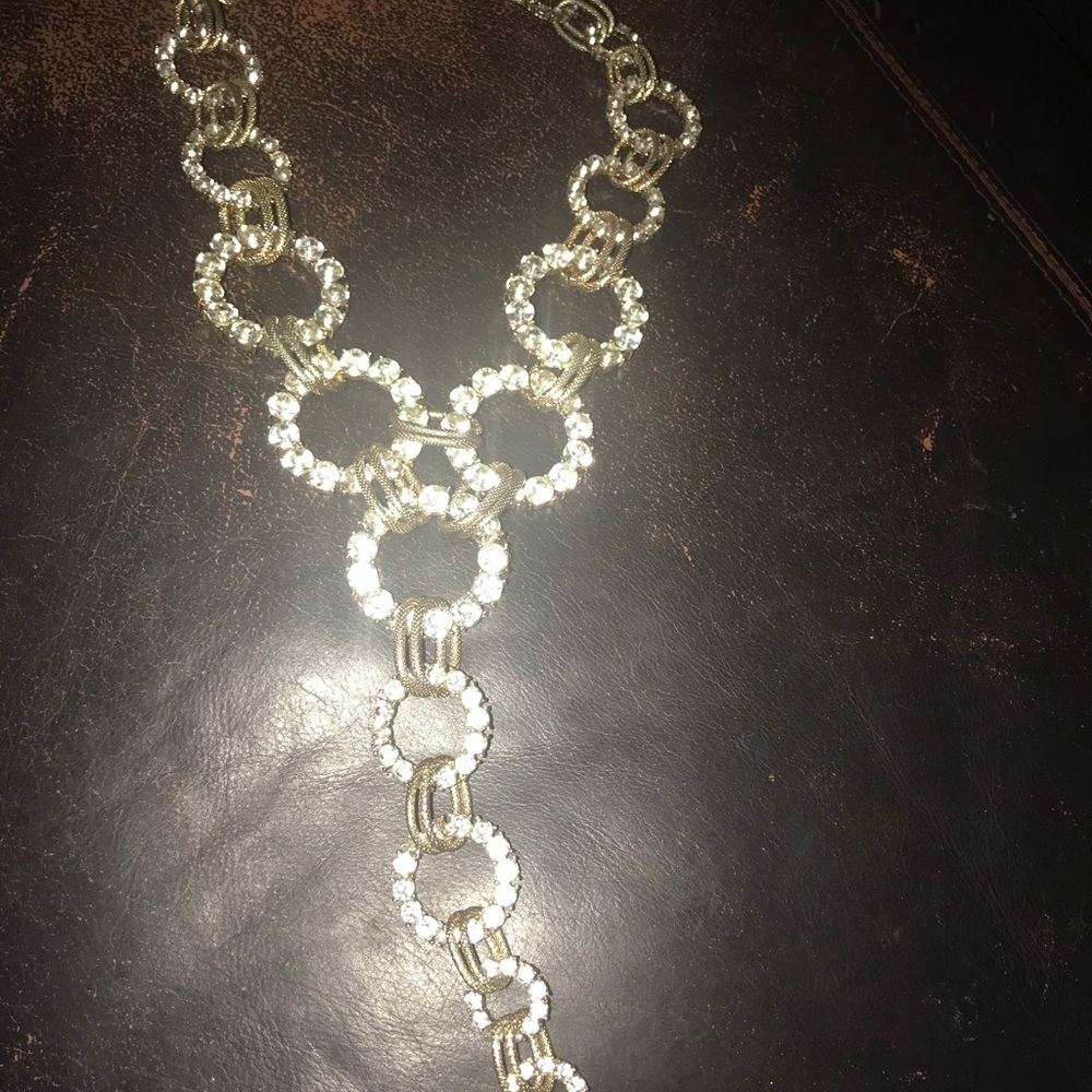 A gold and rhinestone Y necklace.