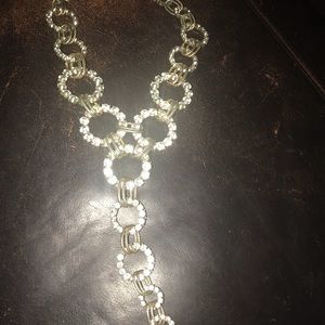 A gold and rhinestone Y necklace.