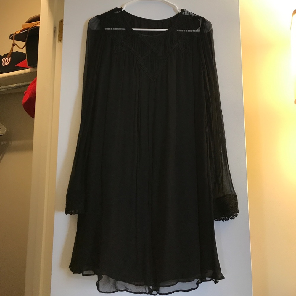 Black dress with detail on wrist and chest.