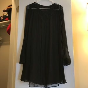 Black dress with detail on wrist and chest.