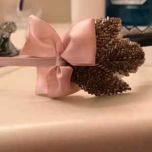 Metal headband with beaded design and pink bow.