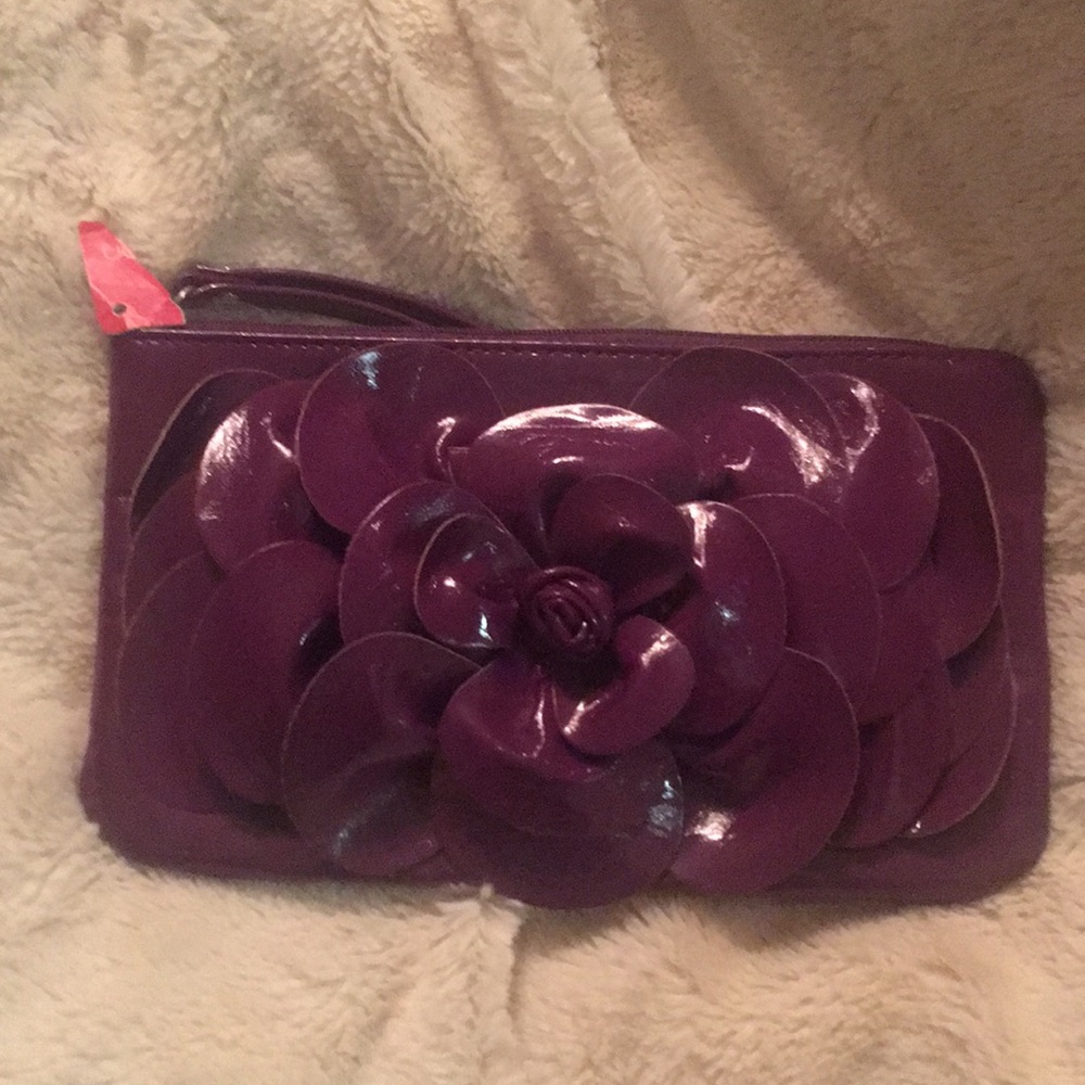 Small purple wristlet purse with flower .