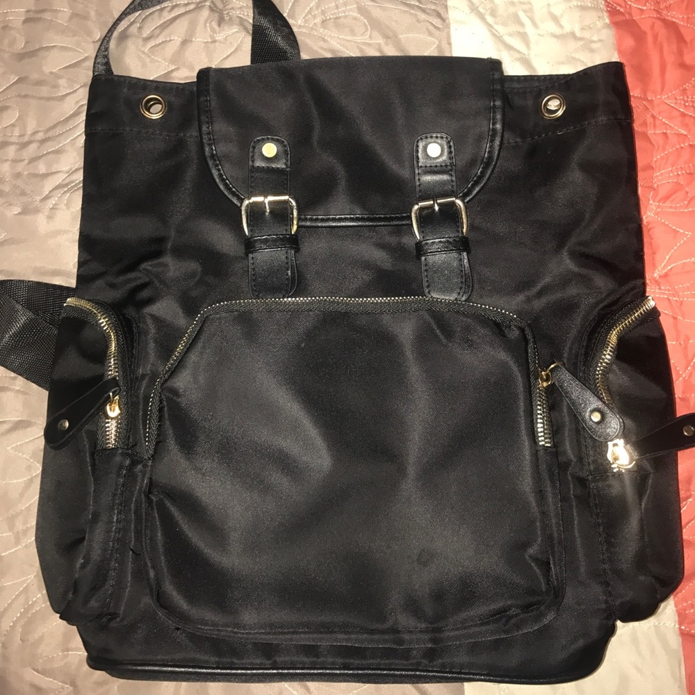 All black backpack, silver zippers and buttons