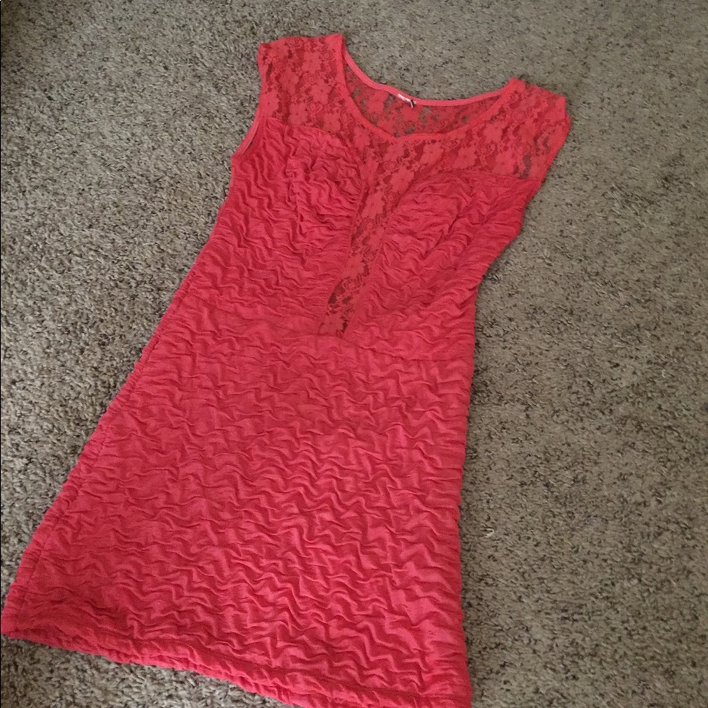 A pink dress with lace detailing at the top