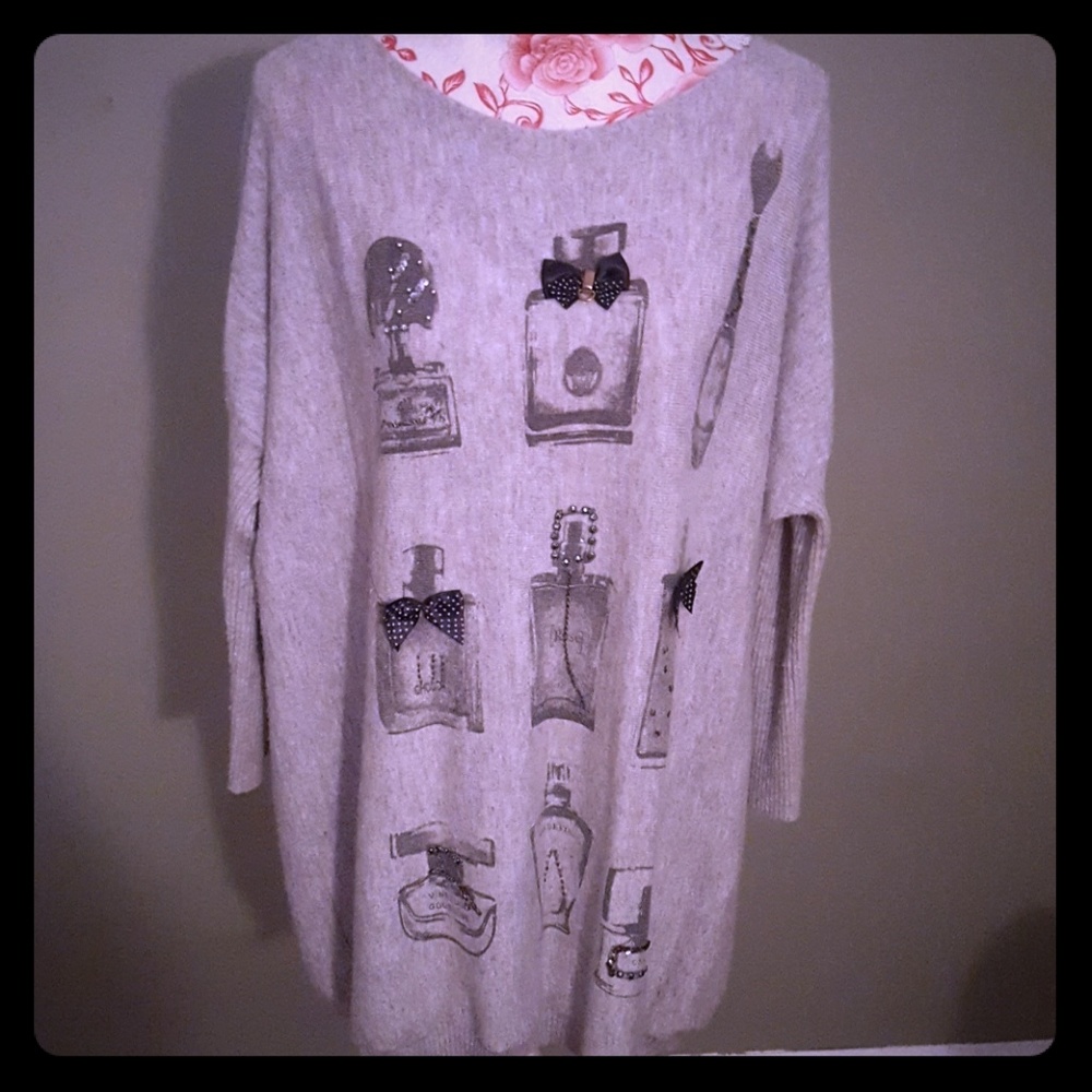 Grey angora sweater with embellishing details.