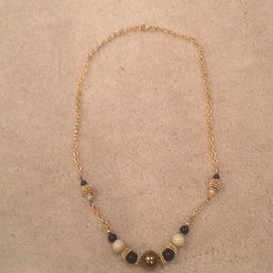 Necklace with gold, black and cream beads.