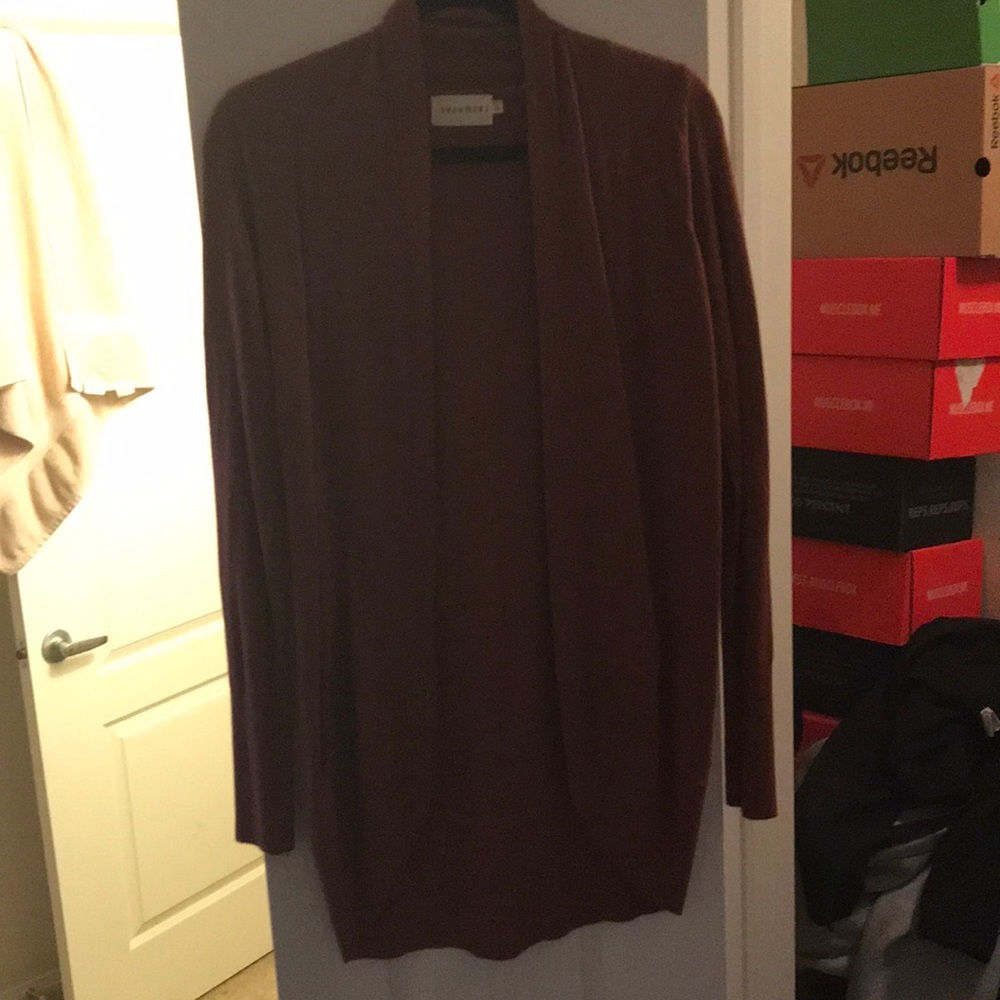 A pinkish/ orange cardigan sweater