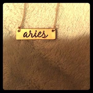 A Claire’s necklace that says “Aries” in cursive✨