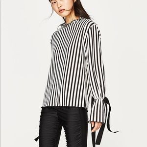 Striped shirt with open back and ruffled neck.