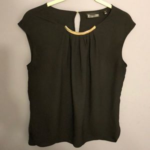 Black sleeveless blouse with gold neckline detail