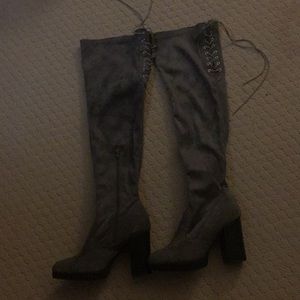 Thigh high heeled gray boots.