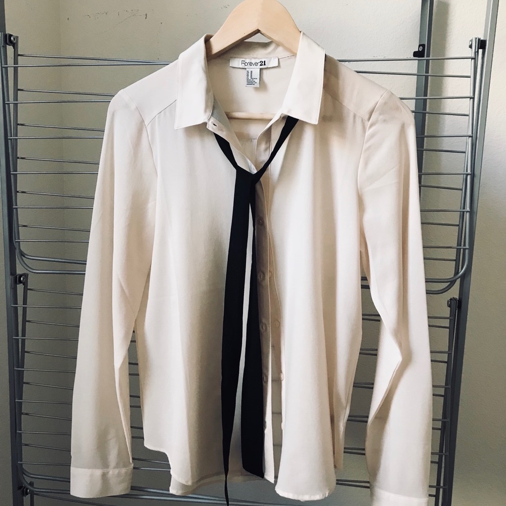 Cream button up shirt with black tie accessory