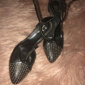 Studded, black platform t-strap stiletto heels.