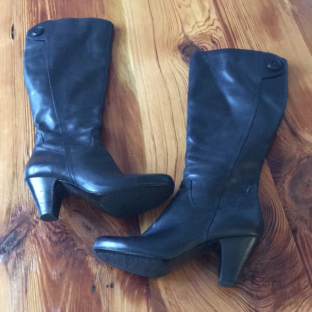 Black leather heeled knee boots.