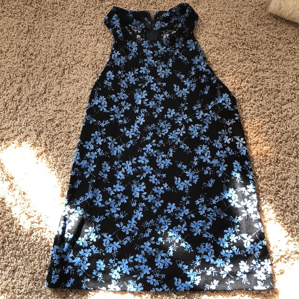 Black sleeveless top with blue flowers.